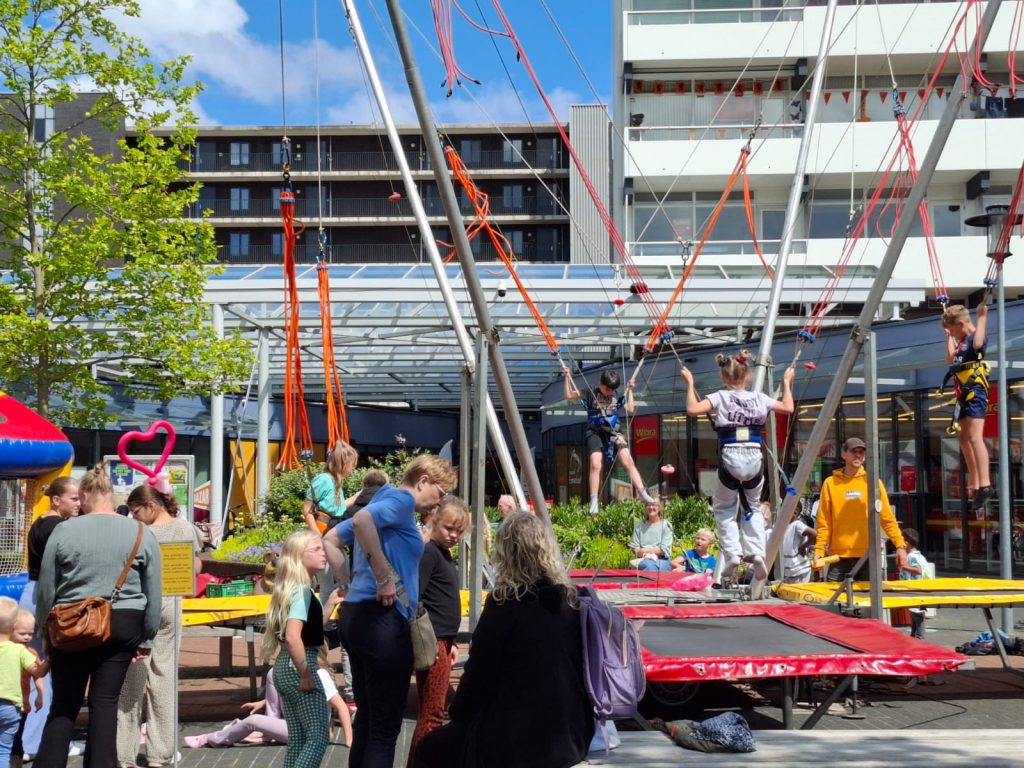 Kinderen spelen op trampolines buiten.
